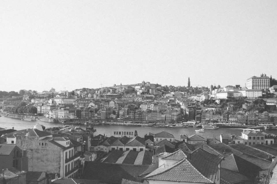Black and white aerial view of Porto, Portugal cityscape with rooftops and river.